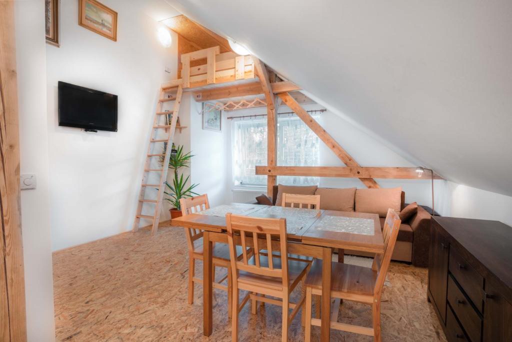 - un salon avec une table et des chaises ainsi qu'un escalier dans l'établissement Apartman Odolov Jestřebí hory, à Malé Svatoňovice