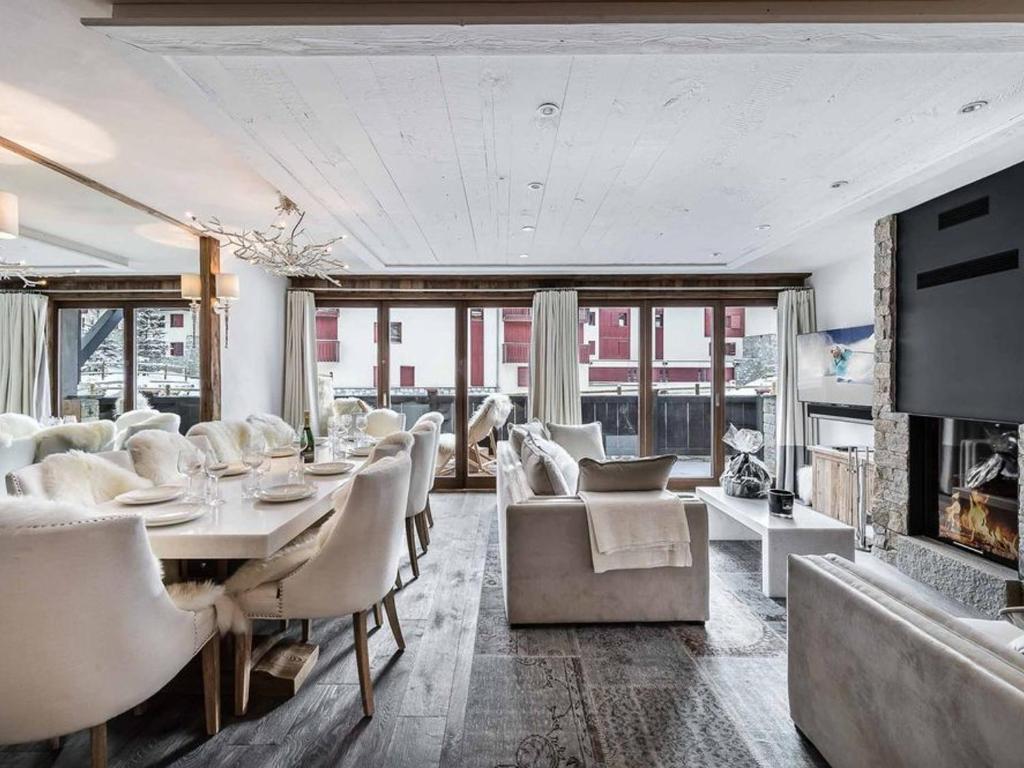 une salle à manger avec une table et des chaises et une cheminée dans l'établissement Appartement duplex luxueux avec sauna – 500m des pistes à Val d'Isère - FR-1-567-17, à Val dʼIsère
