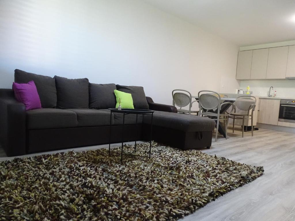 un soggiorno con divano nero e tappeto di Ninas Apartments a Mostar