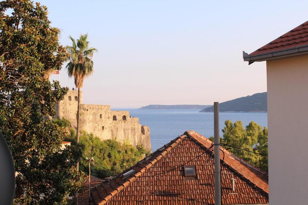 een uitzicht op een kasteel en de oceaan en gebouwen bij Apartments Iris in Herceg-Novi