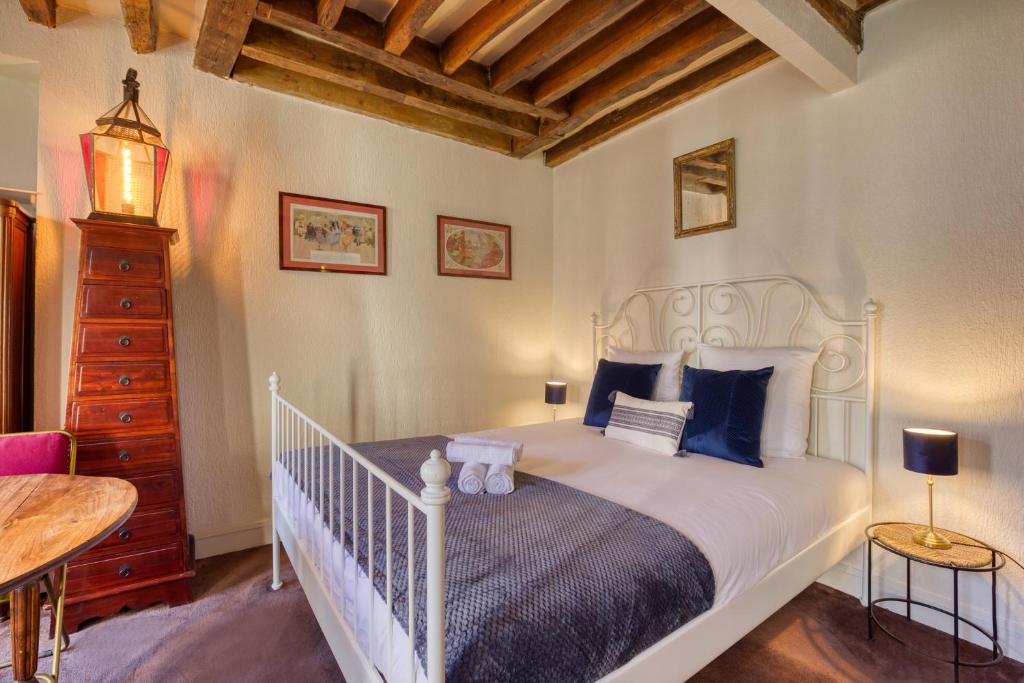 a bedroom with a white bed with blue pillows at Charme de l'ancien aux portes de Paris ! in Charenton-le-Pont