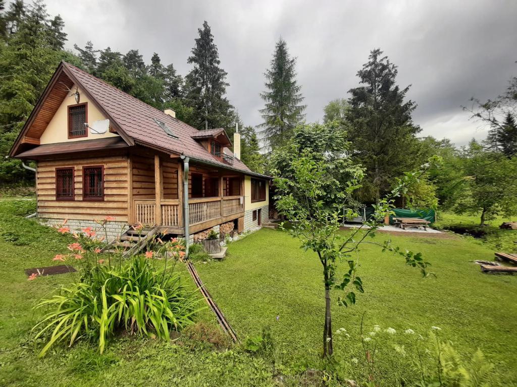 a log cabin in a yard with a yard at Chata Konzajf in Hrabušice
