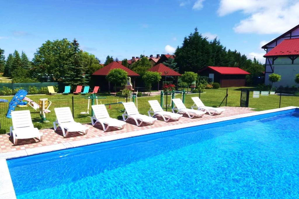 a group of lounge chairs and a swimming pool at Michałek w Rowach in Rowy