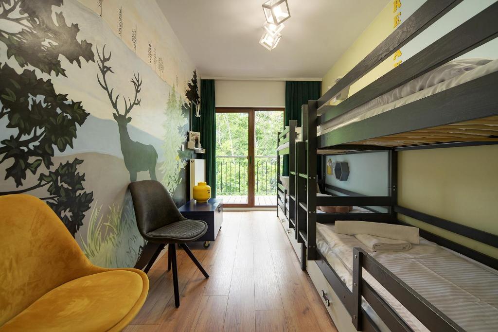 Cette chambre comprend 2 lits superposés et une chaise. dans l'établissement Słoneczny apartament z widokiem na góry, à Szklarska Poręba