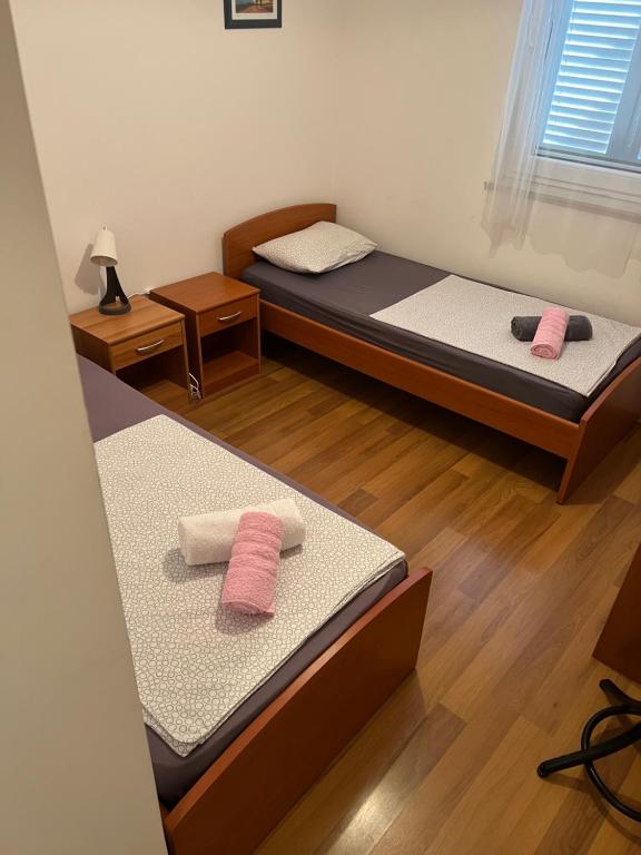 2 łóżka w pokoju z 2 różowymi ręcznikami w obiekcie Apartman LOTA w Novalji
