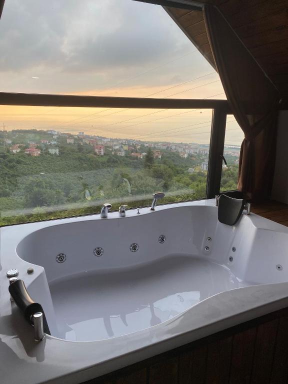 a white bath tub in a room with a window at VİLLA DENİZ , KiRAZ in Trabzon