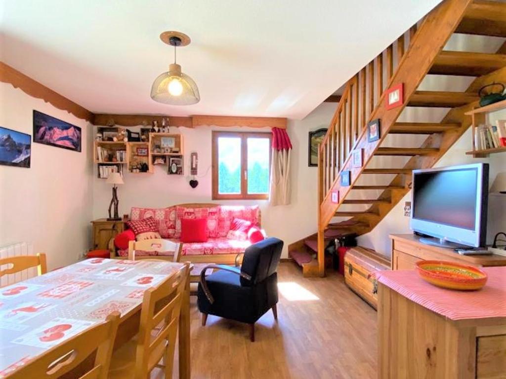 a living room with a dining table and a staircase at Chalet La Joue du Loup, 3 pièces, 8 personnes - FR-1-504-3 in Le Dévoluy