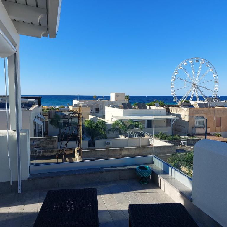 a view of the beach from a balcony with a ferris wheel at B&B il Colibrì in San Vito lo Capo