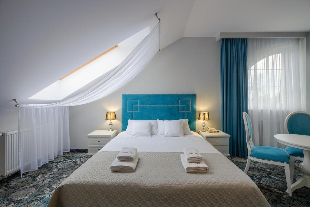 ラドムにあるHotel Lordの大きなベッドとタオル2枚のある寝室