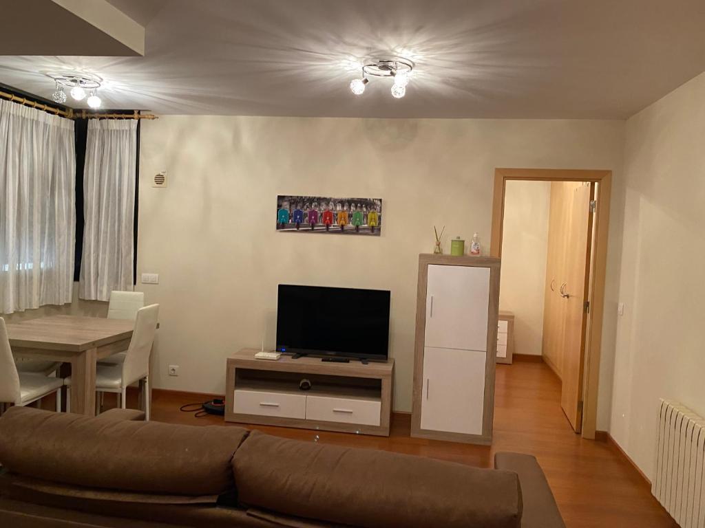 een woonkamer met een bank, een tv en een tafel bij Canillo L'Areny Star in Canillo