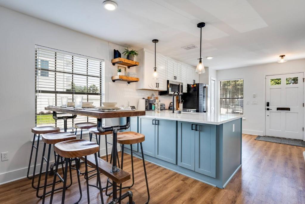 a kitchen with blue cabinets and bar stools at Shore Nuff in Jacksonville Beach