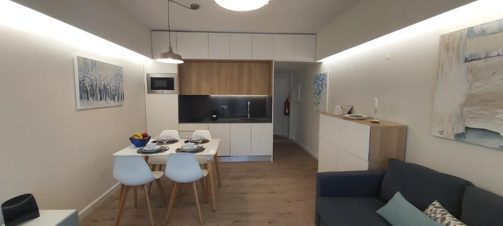 cocina y sala de estar con mesa y sillas. en Apartamento S. João en Alvor