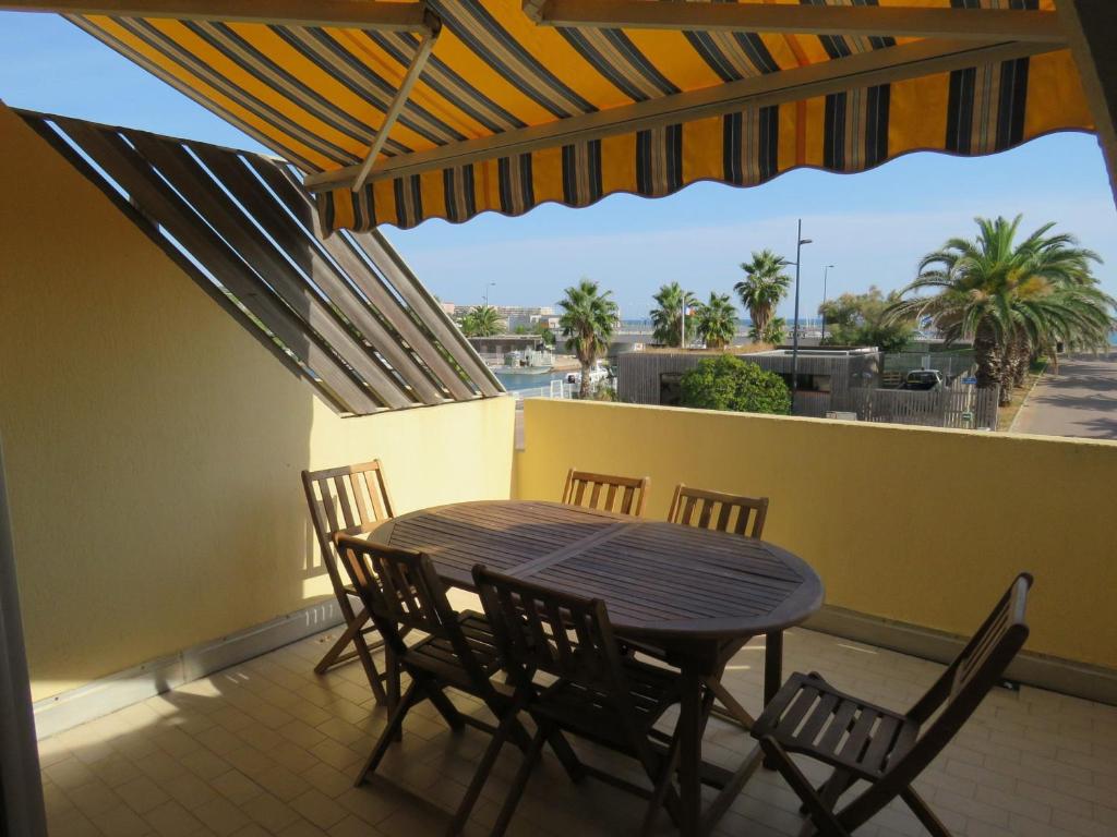 un patio avec une table et des chaises sur un balcon dans l'établissement Appartement T2 à Sète - Terrasse, Loggia, Front de Mer, Parking Privé - FR-1-472-121, à Sète