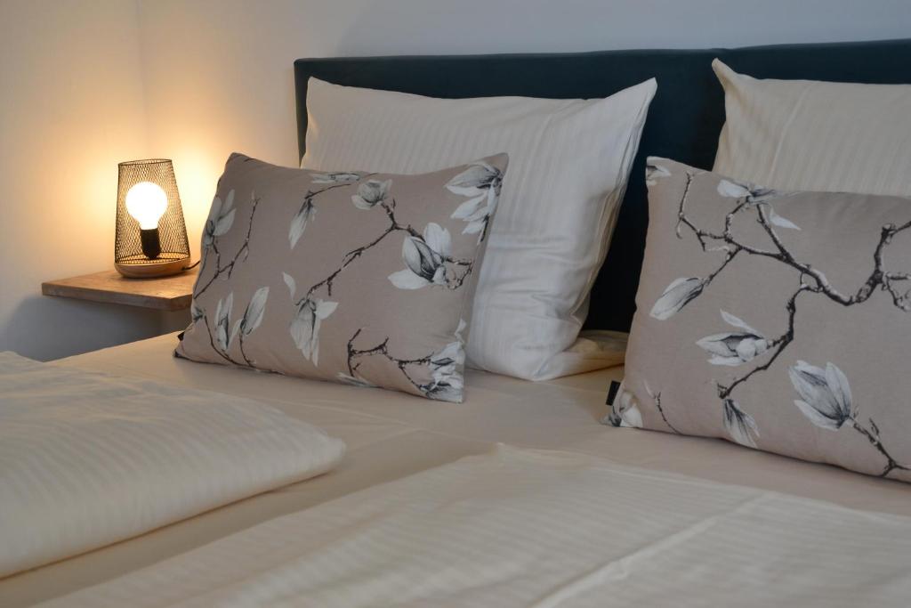 a bed with two pillows and a lamp on it at Christian Gartenhotel in Nieder-Olm