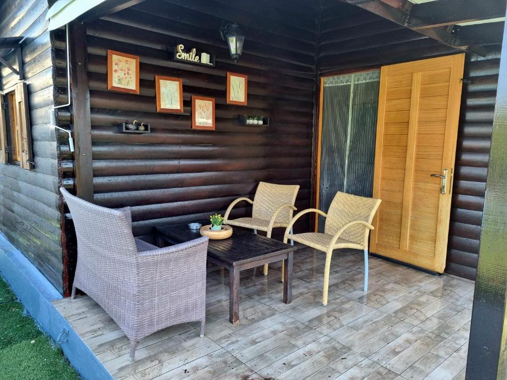 un patio con sedie in vimini e un tavolo su una casa di Wooden house corfu a Halikounas