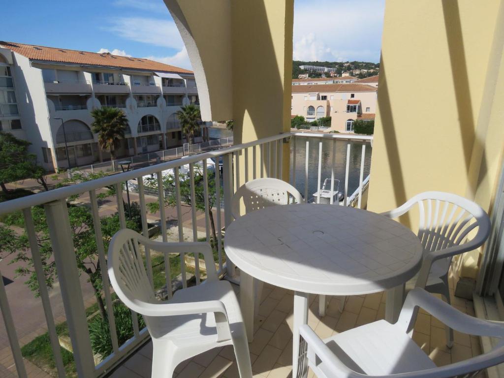 un patio avec une table et des chaises sur un balcon dans l'établissement Studio à Sète avec terrasse, cuisine équipée et vue marina - FR-1-472-149, à Sète