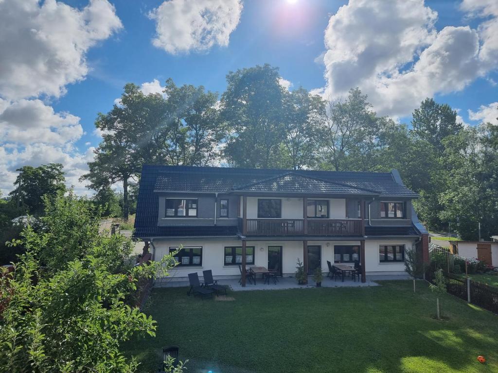 une grande maison avec une cour avec de l'herbe et des arbres dans l'établissement Ferienhaus Kaiserhof, à Markkleeberg