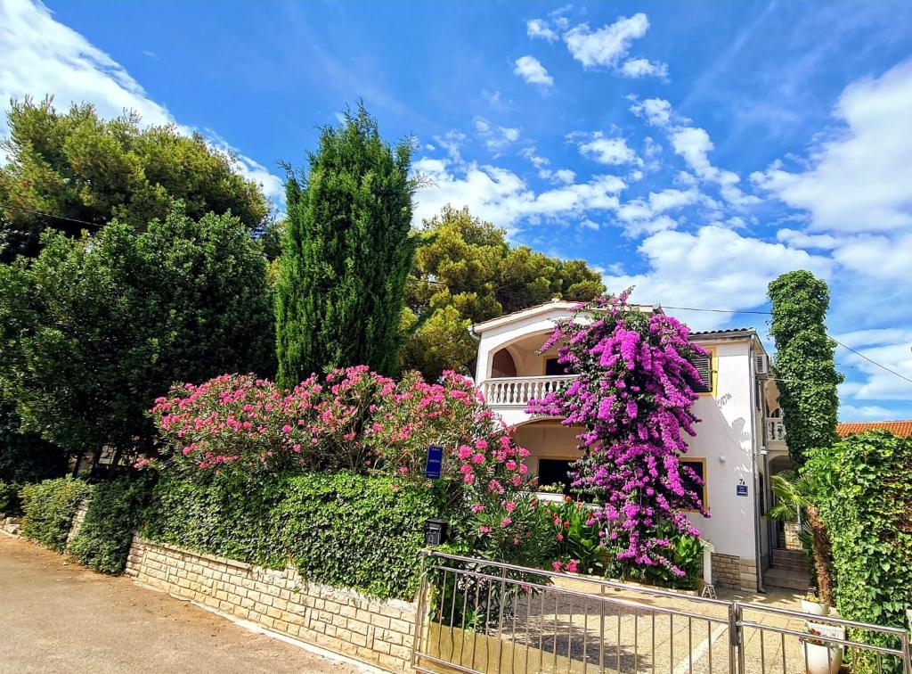 een huis met paarse bloemen op een hek bij Apartment Luna in Vodice