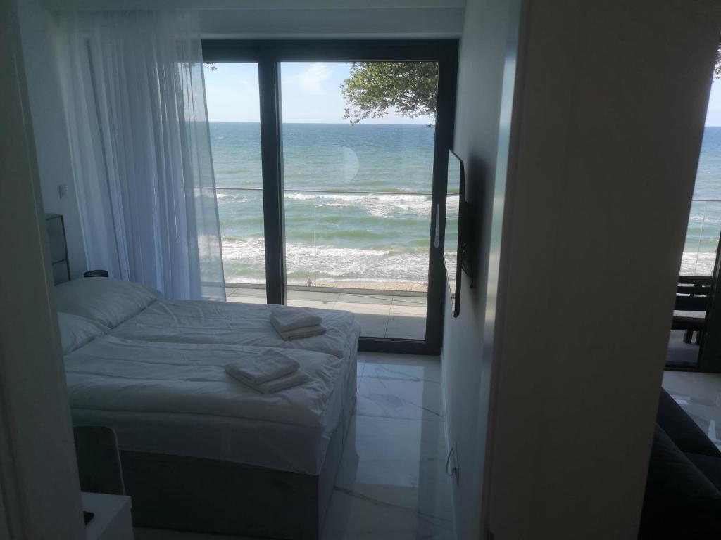 um quarto com uma cama e vista para o oceano em Apartament z widokiem na morze w kompleksie Hevenia em Rewal