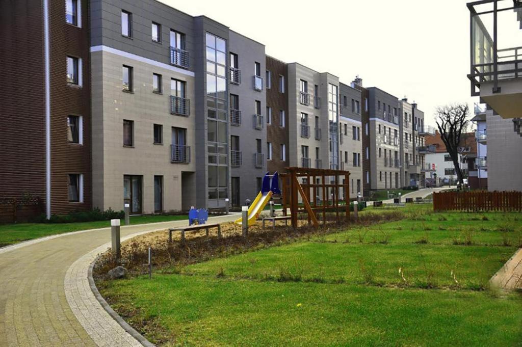 un parque con parque infantil frente a algunos edificios en Sopotinn Apartment en Sopot