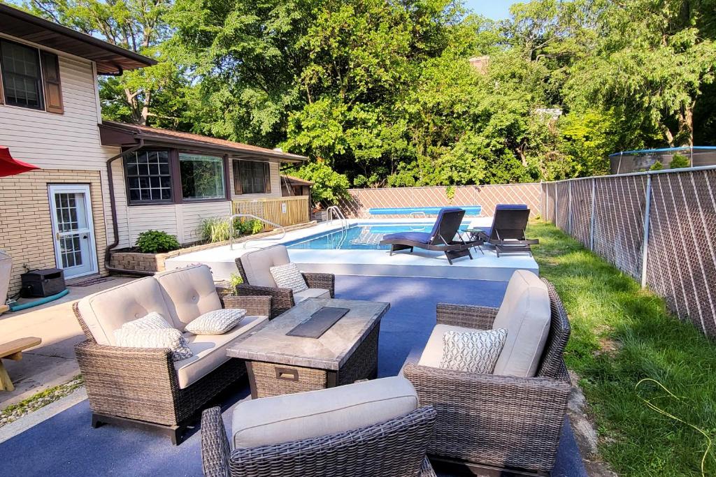a patio with wicker chairs and a swimming pool at Spacious Getaway with Heated Private Pool! in Michigan City