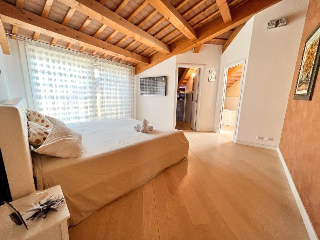 een slaapkamer met een groot bed en een groot raam bij ERMAN HOUSE Mansarda sulla Riviera del Brenta Venezia in Dolo