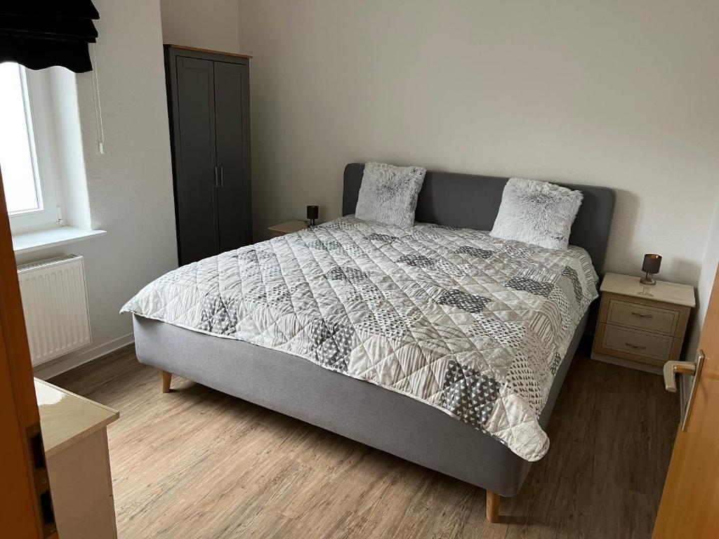 a bedroom with a bed with a comforter and pillows at Ferienwohnung im Mehrfamilienhaus in Weißwasser