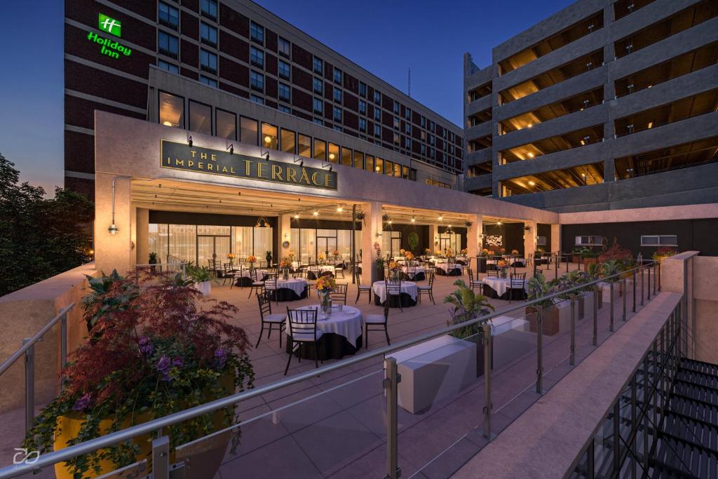 a hotel patio with tables and chairs in front of a building at Holiday Inn Lancaster, an IHG Hotel in Lancaster