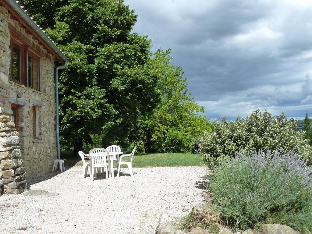 un groupe de chaises assises sur le côté d'un bâtiment dans l'établissement Charmant loft en campagne, à La Clastre