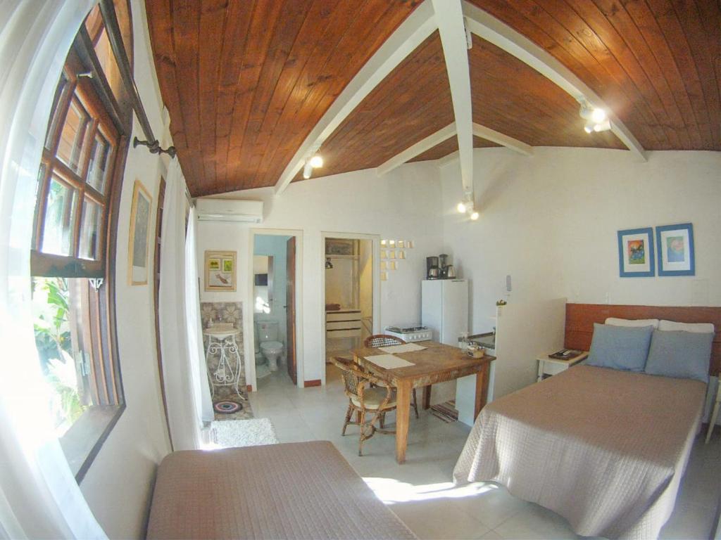 1 dormitorio con 1 cama y 1 mesa en una habitación en Hospedaria Shaolin Estúdio na Lagoa da Conceição, en Florianópolis