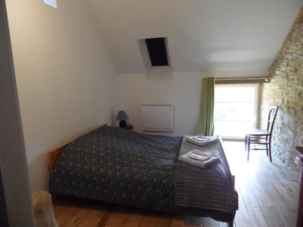 1 dormitorio con cama, mesa y ventana en Gîte à la ferme en pleine nature, en Pleine-Fougères