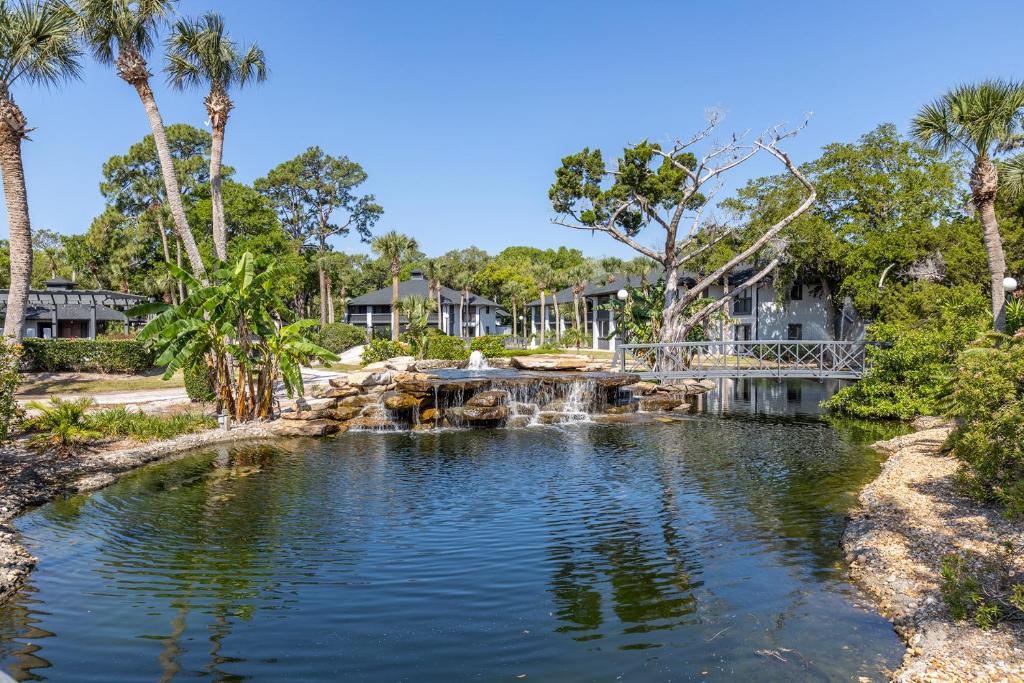 a pond with a waterfall in a yard with palm trees at Legacy Vacation Resorts - Palm Coast in Palm Coast