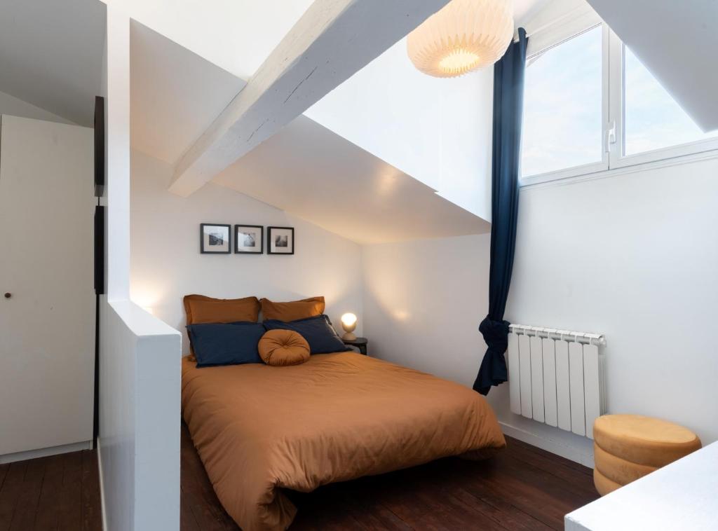 sypialnia z łóżkiem i dużym oknem w obiekcie Le Nid Concorde - T2 de charme - Calme w Tuluzie