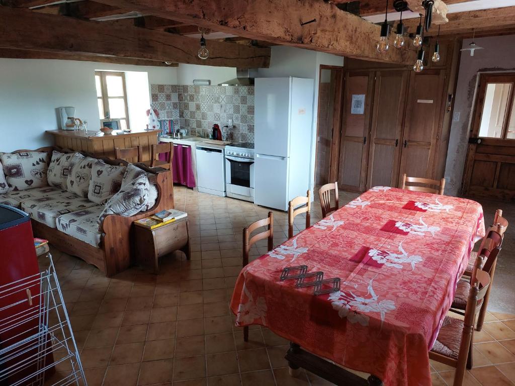 een woonkamer met een tafel en een keuken bij Gîte 11 personnes avec extérieur in Saint-Maurice-de-Rotherens