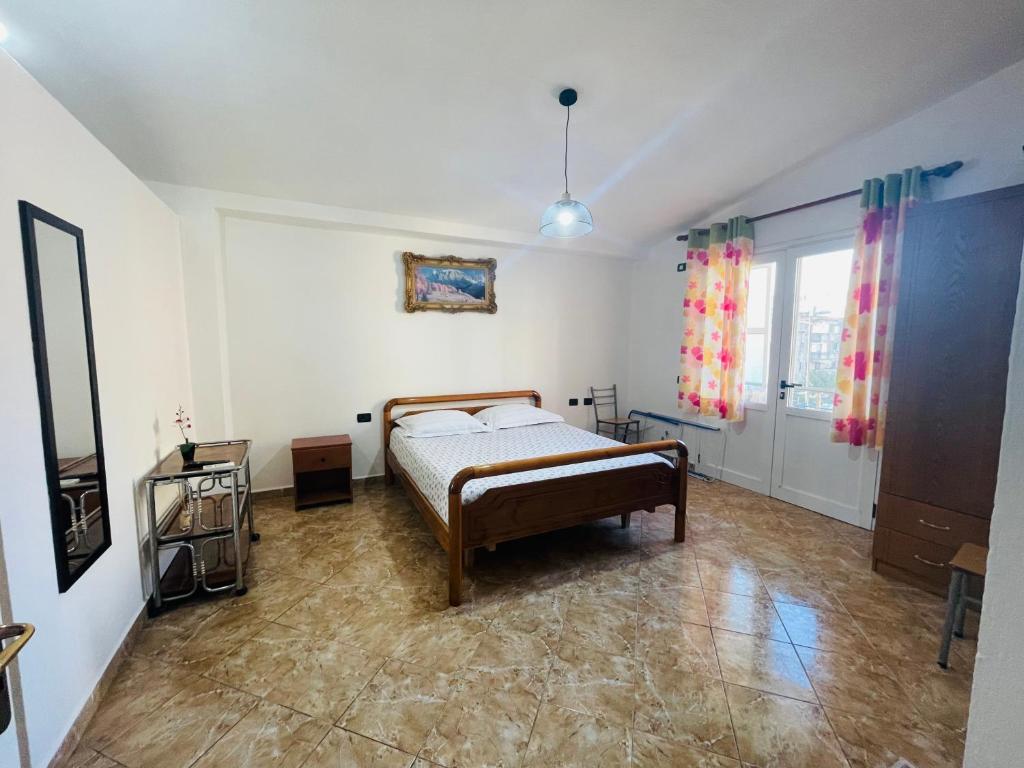 1 dormitorio con cama y ventana grande en Jazoj Family hotel, en Orikum