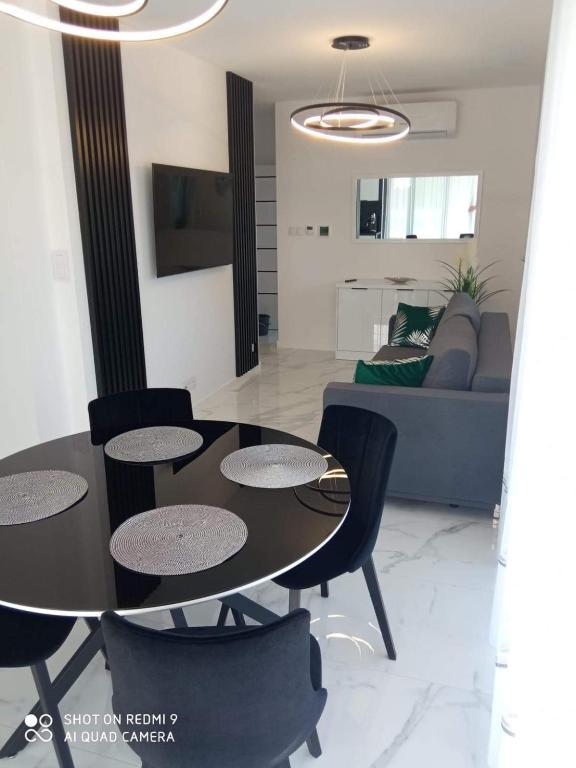 a living room with a table and chairs and a couch at Apartament z bocznym widokiem na morze w kompleksie Hevenia in Rewal