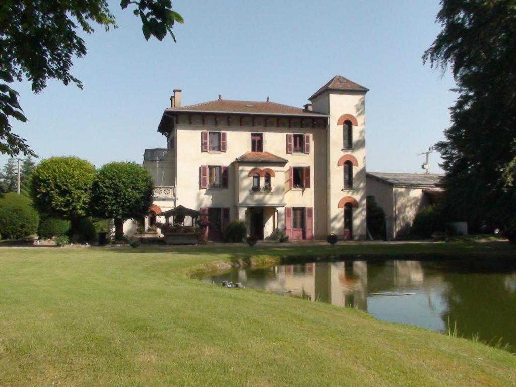 una casa vieja con un estanque delante de ella en Domaine de Marchal - chambres et table d'hôtes, en Celles-sur-Durolle