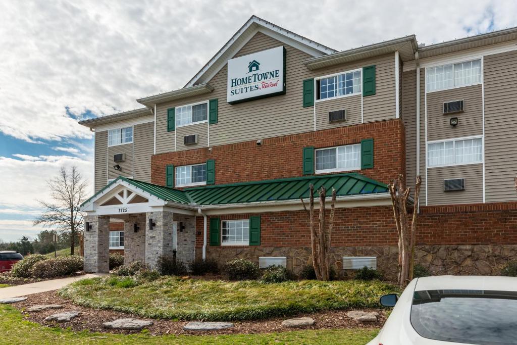 a building with a sign on the front of it at HomeTowne Studios & Suites by Red Roof Charlotte - Concord in Concord