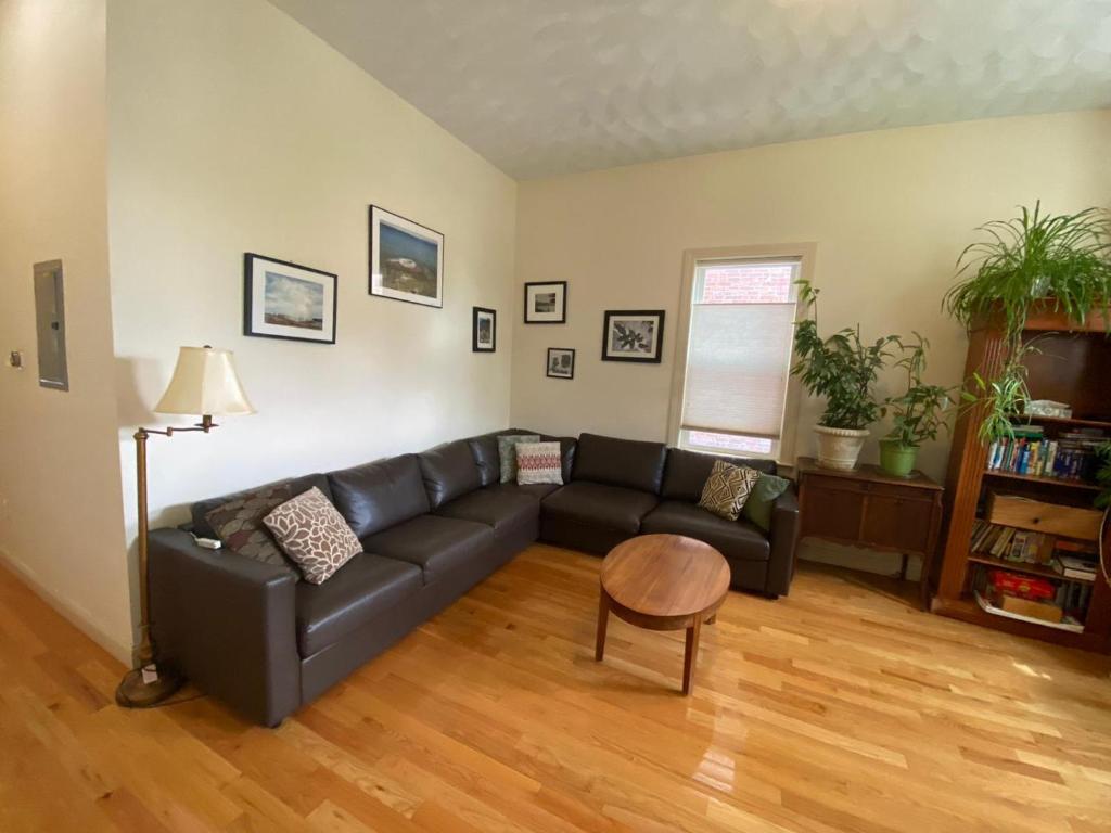 a living room with a black couch and a table at Egleston Square Condo Jamaica Plain in Boston
