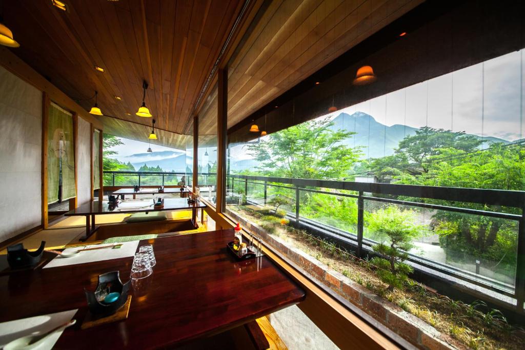 a room with a large window with a view of the mountains at Hisuinoyado Reimei in Yufu