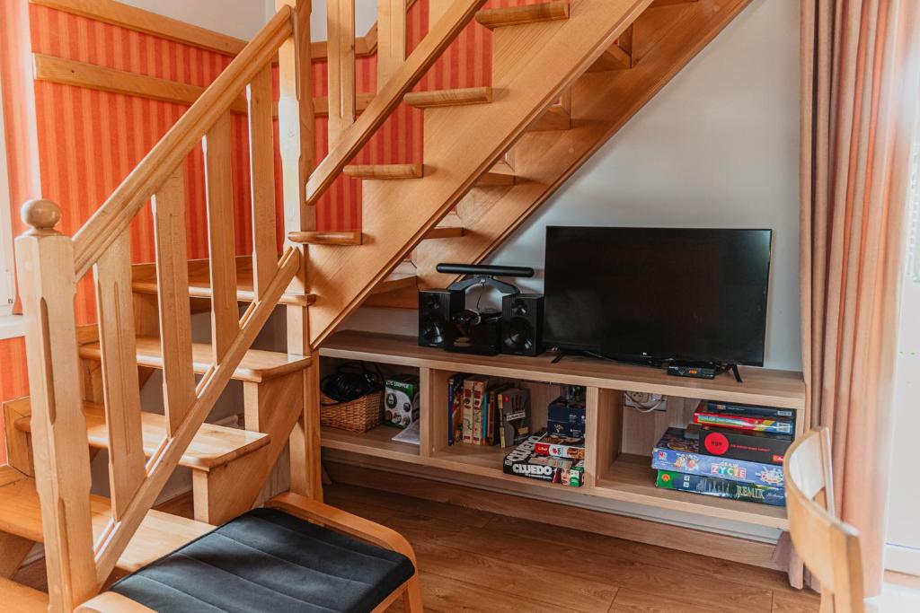 Televízia a/alebo spoločenská miestnosť v ubytovaní Szmaragdowy domek