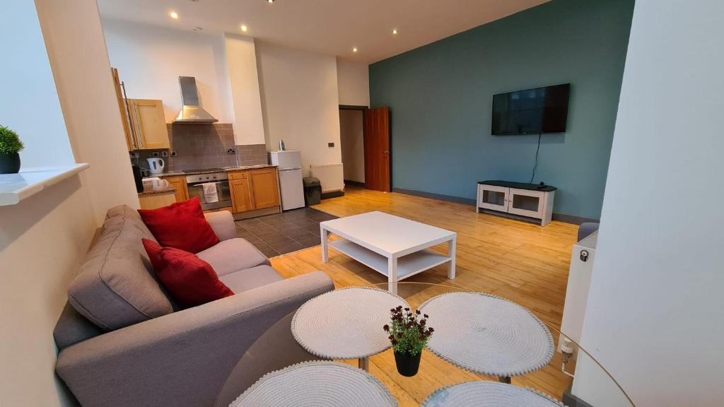 a living room with a couch and a table at Spacious, bright and airy city centre flat. Unique converted Mill. in Manchester