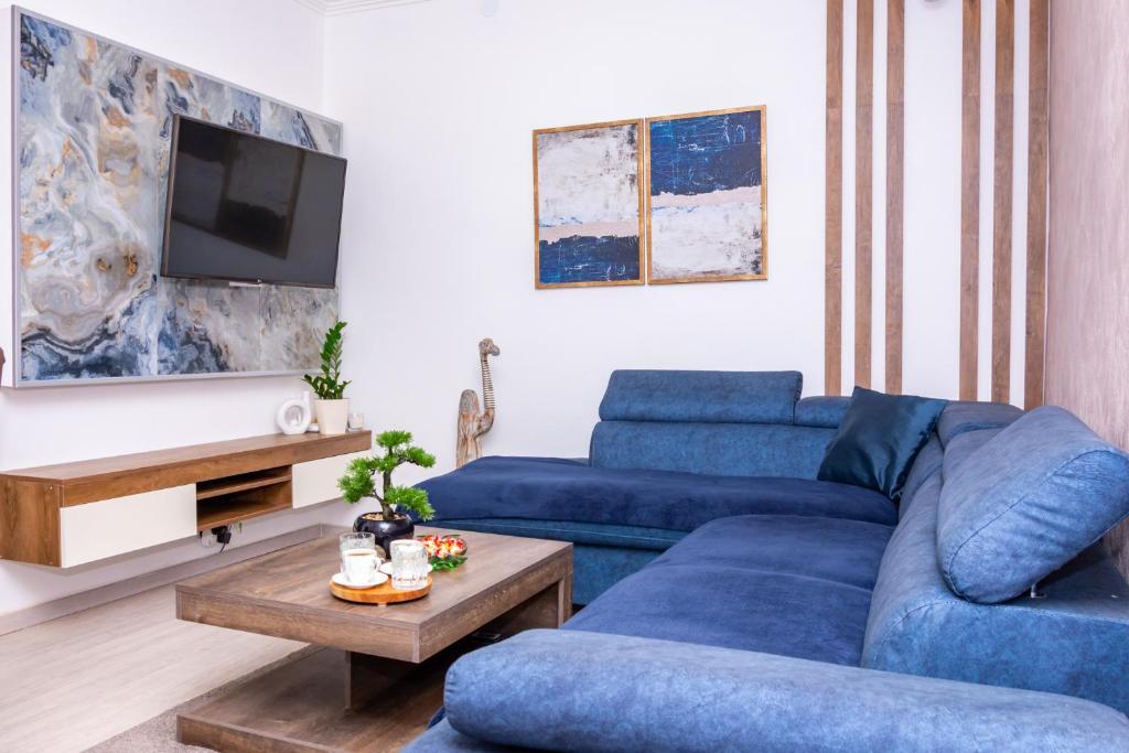 a living room with two blue couches and a tv at HONEYMOON APARTMAN in Soko Banja