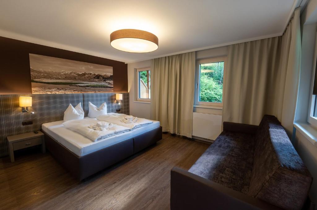 une chambre d'hôtel avec un lit et un canapé dans l'établissement Das Lindtal - Appartements, à Finkenberg