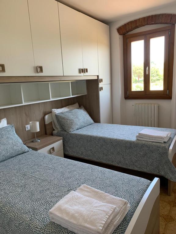 a bedroom with two beds and a window at IL MESSINO in Montevarchi