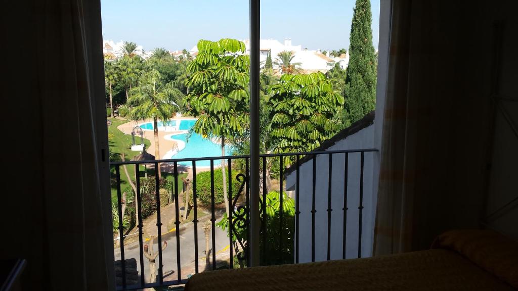 Habitación con vistas a la piscina desde una ventana en Costa ballena, playa del infante, en Cádiz