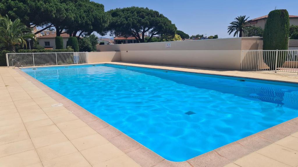 une grande piscine avec de l'eau bleue dans l'établissement T2 dans une jolie résidence arborée de FRÉJUS, à Fréjus