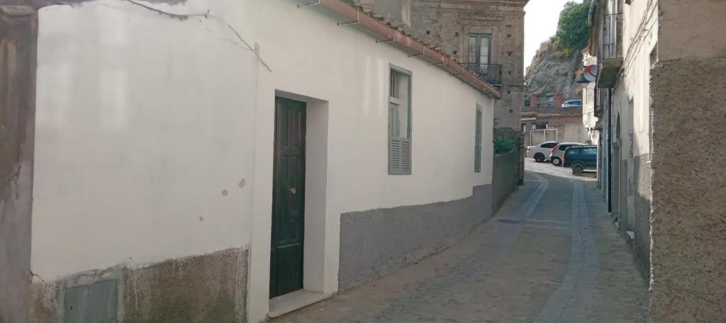 Une allée avec un bâtiment blanc et une porte verte dans l'établissement Case Vacanze Tra Mare e Monti "Da Richard", à Crucoli