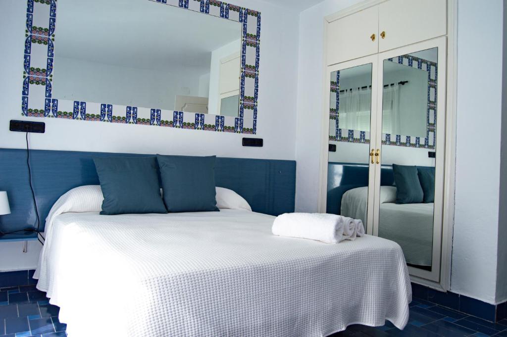 a blue and white bedroom with a bed and a mirror at Zahara Beach EL REFUGIO in Zahara de los Atunes