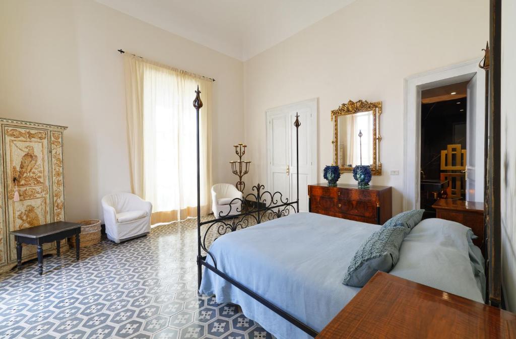 a bedroom with a bed and a table and a mirror at Maison Canopée in Messina